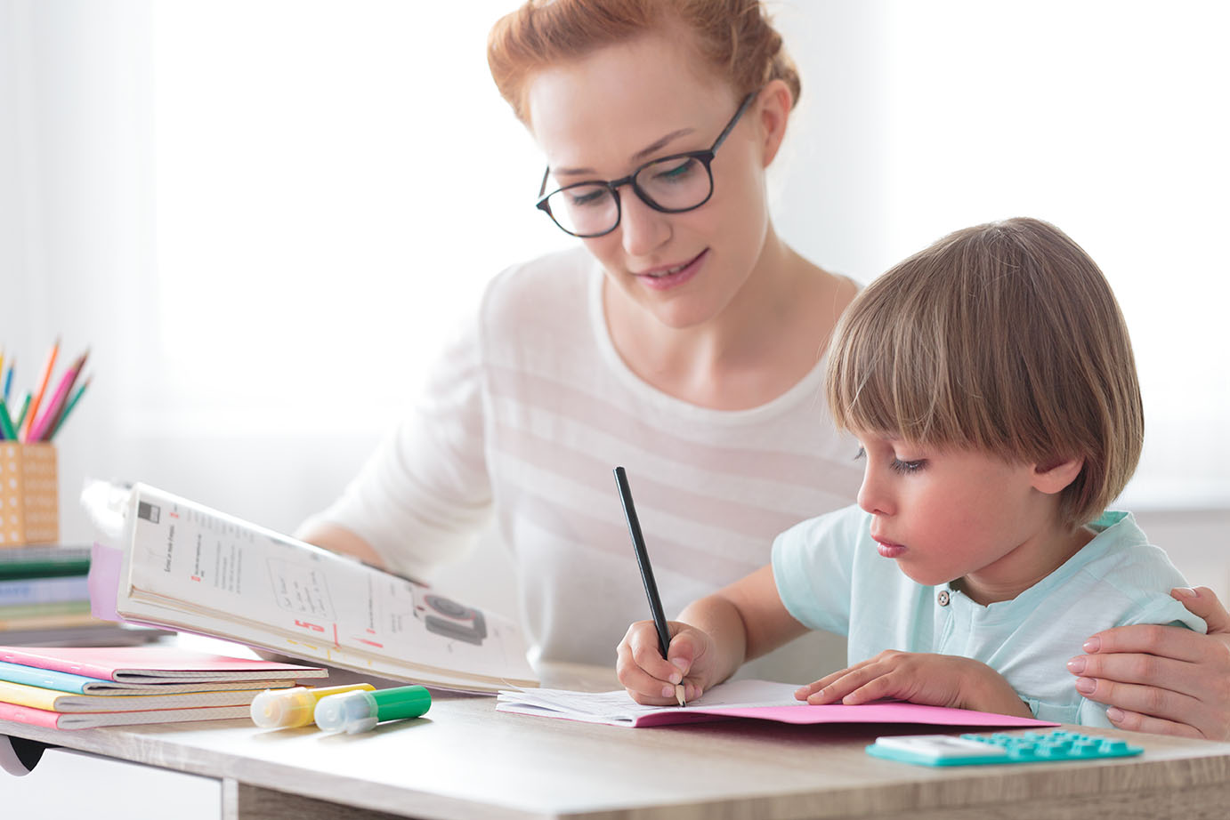 Où consulter une orthophoniste? En milieu scolaire et en garderie! Une intervenante aide un enfant à faire ses travaux.