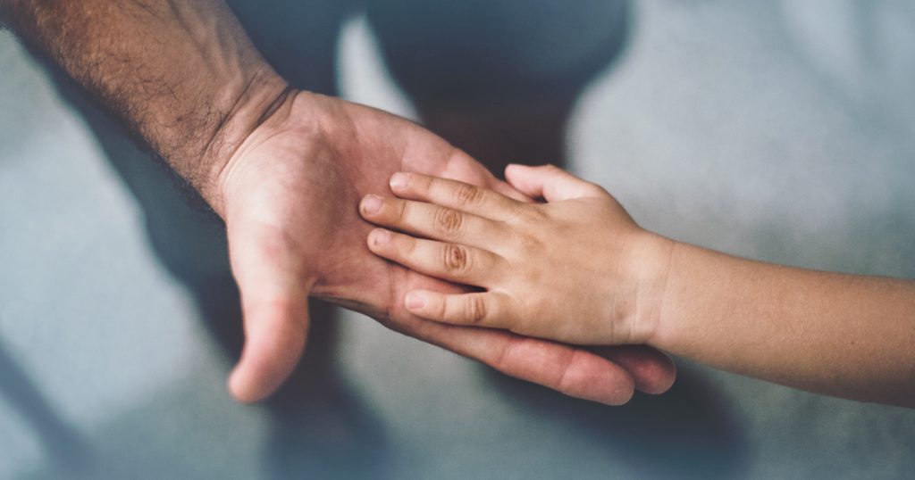 Petite main d'enfant dans une grande main d'adulte.