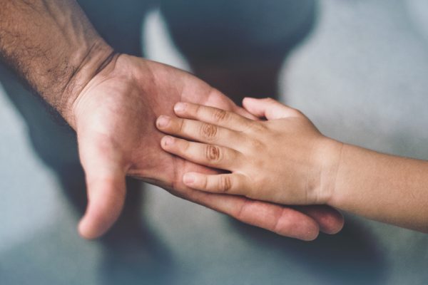 Petite main d'enfant dans une grande main d'adulte.